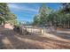 Large backyard with trees, a red shed, stacked firewood, and gated garden area at 34480 Pine Ridge Cir, Elizabeth, CO 80107