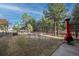 Spacious backyard with mature trees, red outdoor fireplace, and partial fence at 34480 Pine Ridge Cir, Elizabeth, CO 80107