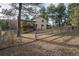 Backyard of the home with partial fencing, grassy areas, mature trees, and a deck overlooking the yard at 34480 Pine Ridge Cir, Elizabeth, CO 80107