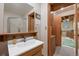 Bright bathroom featuring a vanity with a mirrored medicine cabinet and shower with glass doors at 34480 Pine Ridge Cir, Elizabeth, CO 80107