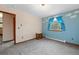 Bright bedroom with blue accent wall, carpet flooring, window overlooking nature, and a nearby closet at 34480 Pine Ridge Cir, Elizabeth, CO 80107