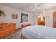 Sunlit bedroom features a ceiling fan, carpet floor, natural wood furniture, and an ensuite bathroom at 34480 Pine Ridge Cir, Elizabeth, CO 80107