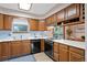 Well-lit kitchen features wood cabinetry, modern appliances, and a view to the deck area at 34480 Pine Ridge Cir, Elizabeth, CO 80107