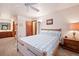 Comfortable main bedroom featuring neutral tones, natural light, adjacent bathroom, and wooden furniture at 34480 Pine Ridge Cir, Elizabeth, CO 80107