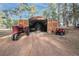 A shed is filled with equipment and has tractor and four-wheeler parked outside at 34480 Pine Ridge Cir, Elizabeth, CO 80107