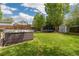 This backyard features a hot tub, a trampoline, green grass, a shed, and a wood fence at 1200 Butterfield Ln, Castle Rock, CO 80104