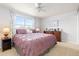 This bedroom features a ceiling fan, window with curtains, and dresser with decorations at 1200 Butterfield Ln, Castle Rock, CO 80104