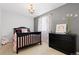 The Bedroom features a black crib, chandelier, window with curtains, and wall decor at 1200 Butterfield Ln, Castle Rock, CO 80104