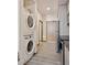 Hallway featuring modern stacked washer and dryer, and wood-look flooring at 603 Inca St # 330, Denver, CO 80204