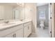 Bright bathroom featuring a double sink vanity and a view into the toilet room at 6172 N Liverpool St, Aurora, CO 80019
