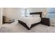 Cozy bedroom with natural light, a plush armchair, and a large bed with dark wood frame at 6172 N Liverpool St, Aurora, CO 80019