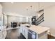 Modern kitchen flows into the dining and living areas and features a large island with white countertops at 6172 N Liverpool St, Aurora, CO 80019