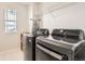 Modern laundry room features state-of-the-art appliances and ample shelving for storage at 6172 N Liverpool St, Aurora, CO 80019