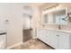 Elegant bathroom featuring double sinks, marble countertops, and a view into the main bedroom at 7922 S Algonquian Way, Aurora, CO 80016
