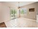 Bright dining area with tile flooring, modern light fixture, and access to outdoor space through sliding glass door at 7922 S Algonquian Way, Aurora, CO 80016