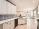 Modern kitchen boasts white cabinetry, stainless steel appliances, and a view into the dining area at 7922 S Algonquian Way, Aurora, CO 80016