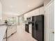 Bright kitchen features sleek black appliances, white cabinets, and open access to the dining area at 7922 S Algonquian Way, Aurora, CO 80016