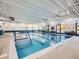 Indoor pool with clear blue water, marked lanes, and ample natural light from surrounding windows and doors at 7922 S Algonquian Way, Aurora, CO 80016