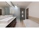 Bright bathroom with double sinks, soaking tub, and walk-in shower with tiled wall at 101 S Humboldt St, Denver, CO 80209