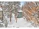 Exterior view of a blue-gray house surrounded by snow-covered trees and landscape at 4888 Silver Spruce Ln, Evergreen, CO 80439