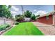 Spacious backyard with lush green grass and a well-maintained fence with a storage shed in the back at 11542 W 29Th Pl, Lakewood, CO 80215