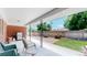 Covered outdoor patio with seating, brick accents, a grill and an expansive fenced backyard at 11542 W 29Th Pl, Lakewood, CO 80215