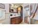Bathroom vanity with warm lighting, tile backsplash and a hardwood floor in the hallway at 11542 W 29Th Pl, Lakewood, CO 80215