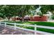 Charming brick home with mature trees, lush lawn, and white picket fence at 11542 W 29Th Pl, Lakewood, CO 80215