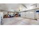 Spacious two car garage featuring ample open space, overhead lighting, and a storage shelf at 11542 W 29Th Pl, Lakewood, CO 80215