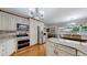 Kitchen with stainless steel appliances, white cabinets, granite countertops and a dining area at 11542 W 29Th Pl, Lakewood, CO 80215