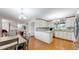 Open kitchen and dining area with white cabinets, granite countertops, and hardwood floors at 11542 W 29Th Pl, Lakewood, CO 80215