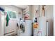 Bright laundry room featuring a washer, dryer, shelves, water heater, and window at 11542 W 29Th Pl, Lakewood, CO 80215