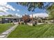 Beautifully landscaped backyard featuring a lush lawn, stone pathway, garden beds, patio, and a relaxing hot tub at 4930 Gray St, Denver, CO 80212