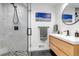 Modern bathroom with glass shower, wooden vanity, stylish fixtures, and neutral tones at 4930 Gray St, Denver, CO 80212