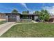 Attractive home with a gray brick exterior, neat landscaping, and an attached garage on a sunny day at 4930 Gray St, Denver, CO 80212