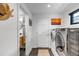 Bright laundry room featuring front loading washer and dryer, access to bathroom, and natural light at 4930 Gray St, Denver, CO 80212