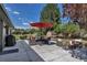 Spacious outdoor patio area with comfortable seating around a fire pit and an umbrella for shade, great for gatherings at 4930 Gray St, Denver, CO 80212