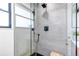 Modern shower with glass door, sleek black fixtures, tiled walls, and wood bench at 4930 Gray St, Denver, CO 80212