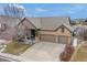 Aerial view of a brick home with a two-car garage and a covered front porch with a blue sky at 7262 Serena Dr, Castle Pines, CO 80108