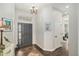 Elegant foyer with dark wood floors, chandelier, and striking front door sets a sophisticated tone at 7262 Serena Dr, Castle Pines, CO 80108