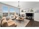 Cozy living room with a fireplace, large windows, and comfortable seating at 7262 Serena Dr, Castle Pines, CO 80108