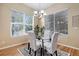 Bright dining area with hardwood floors, modern chandelier, and large windows with natural light at 23951 E Easter Pl, Aurora, CO 80016