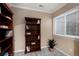 The office features a wooden bookcase, a large window, neutral paint and carpet at 23951 E Easter Pl, Aurora, CO 80016