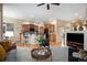 Open-concept living room with a fireplace and views of the kitchen with breakfast bar seating at 23951 E Easter Pl, Aurora, CO 80016