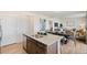 Open concept kitchen with island and stainless steel sink, seamlessly connected to the dining and living areas at 6543 12Th St, Frederick, CO 80530