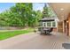 The backyard deck features outdoor dining under an umbrella, overlooking a large grassy yard at 5061 S Florence Dr, Englewood, CO 80111