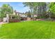 Sprawling backyard with a manicured lawn, mature trees, and outdoor entertaining spaces at 5061 S Florence Dr, Englewood, CO 80111