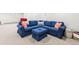Cozy basement living area with a comfortable blue sectional sofa and ottoman, perfect for relaxing and entertaining at 5061 S Florence Dr, Englewood, CO 80111