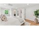 Bright bedroom featuring hardwood floors, white walls, and a view into the bathroom at 5061 S Florence Dr, Englewood, CO 80111