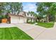 Traditional two-story home with a wide driveway, manicured lawn, and white two car garage at 5061 S Florence Dr, Englewood, CO 80111